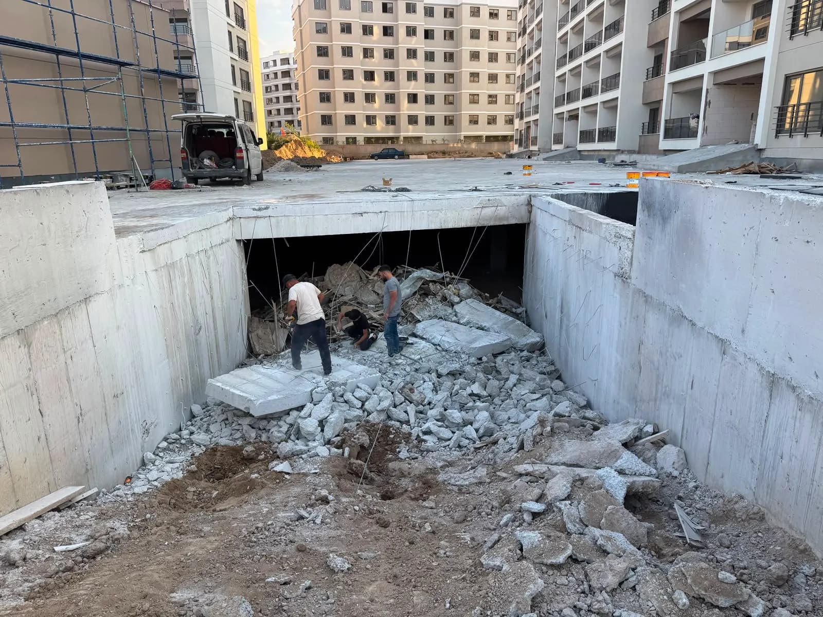 Açılan bodrum açıklığının içinde biriken beton molozu ve moloz üzerinde çalışan ekip