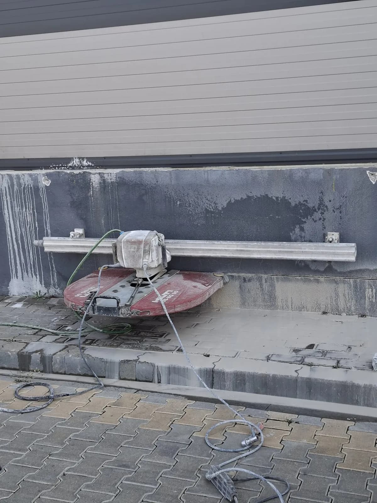 Beton duvara dübellenmiş kılavuz ray ve ray üzerine bağlanmış raylı duvar testeresinin yakın görünümü