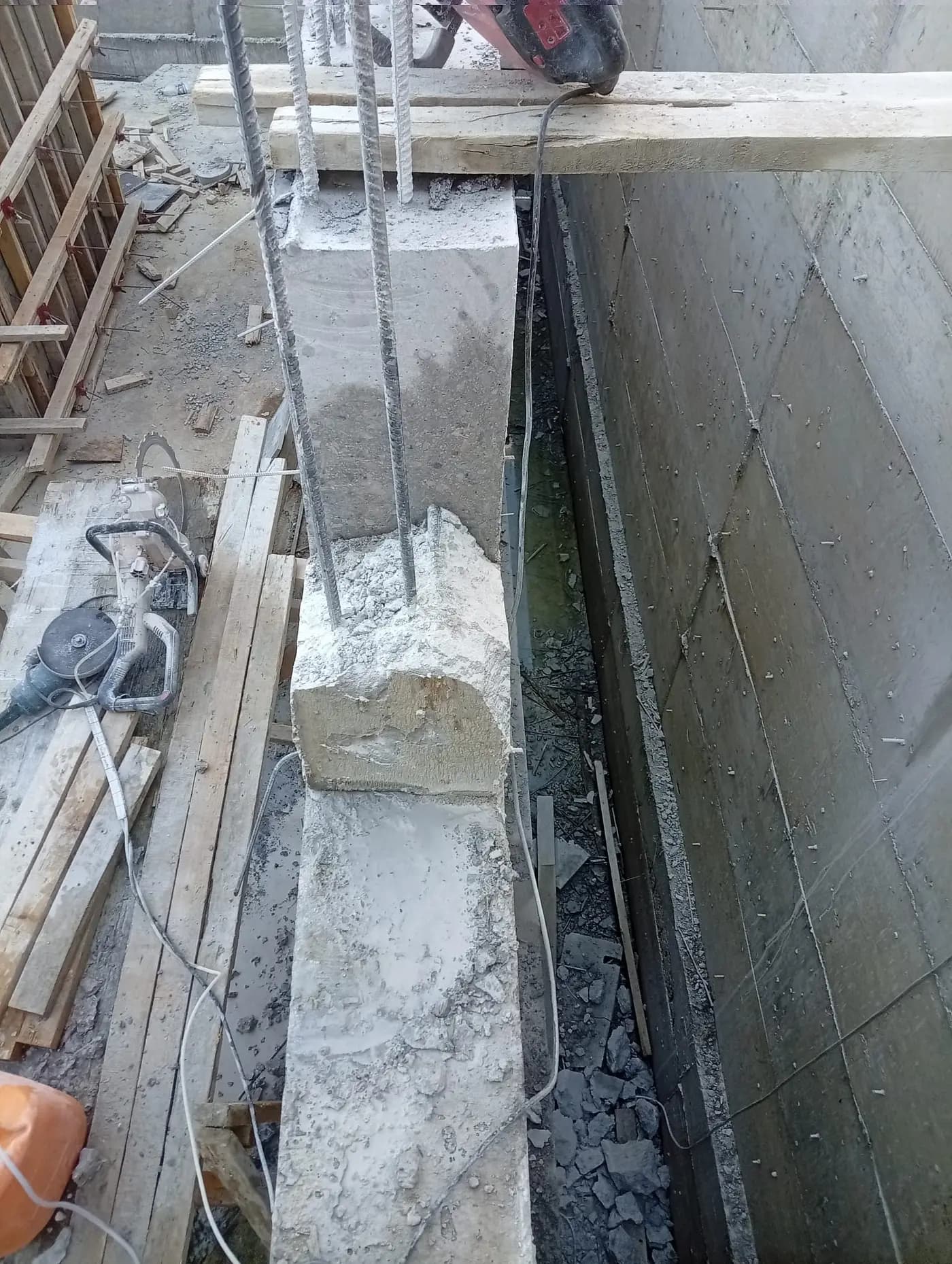 Perde üstünde kot fazlası betonun kırılmasıyla açığa çıkan donatılar ve yanda duran halka testere
