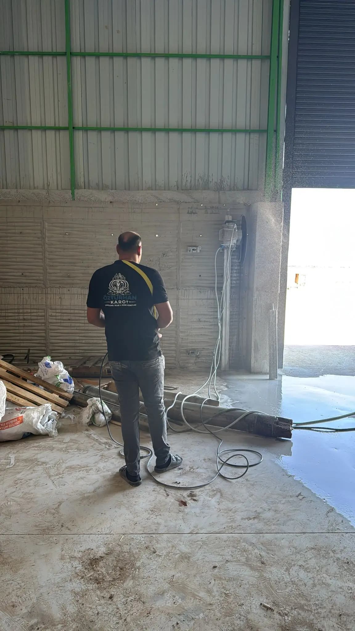 Panel duvarda raya bağlı duvar testeresinin düşey kesim yaparken çıkardığı su püskürtüsü