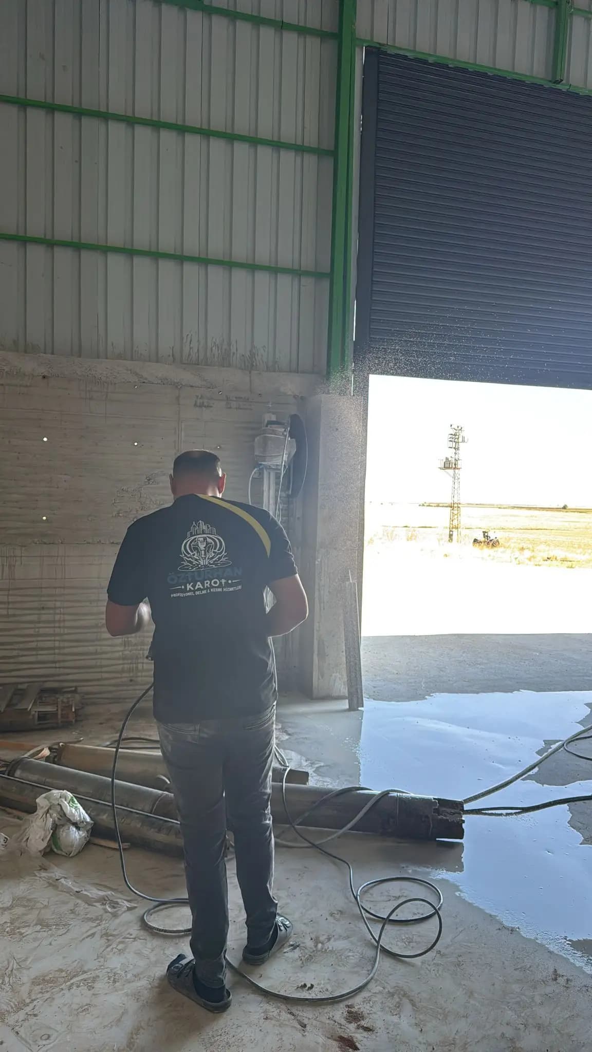Kesim sürerken duvarın karşısında bekleyen personel ve zeminde biriken kesim suyu