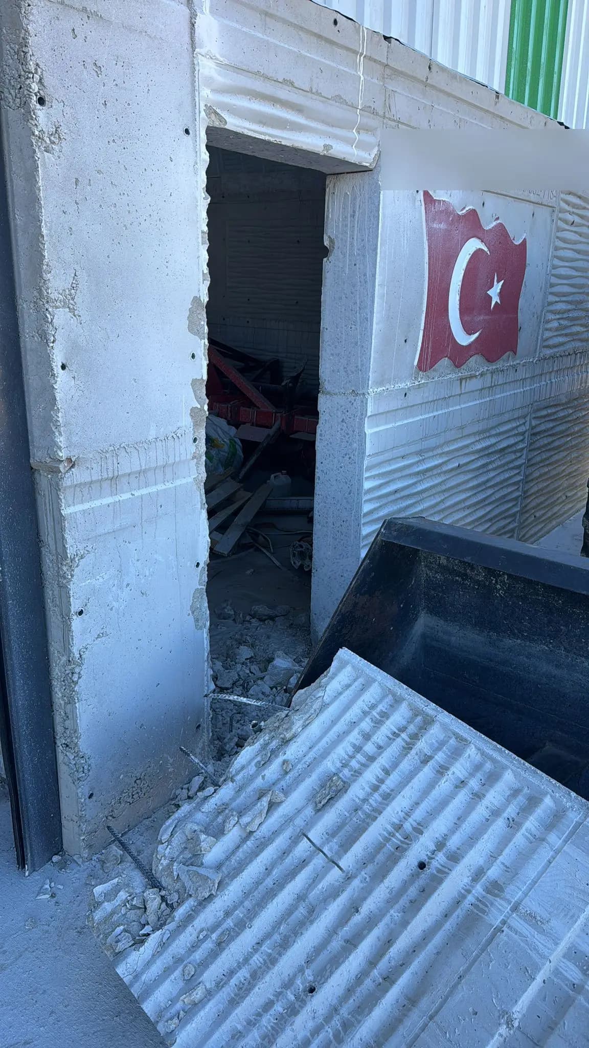 Panel duvarda açılan kapı boşluğu, eşikte biriken beton parçaları ve dışarı alınmış panel parçası
