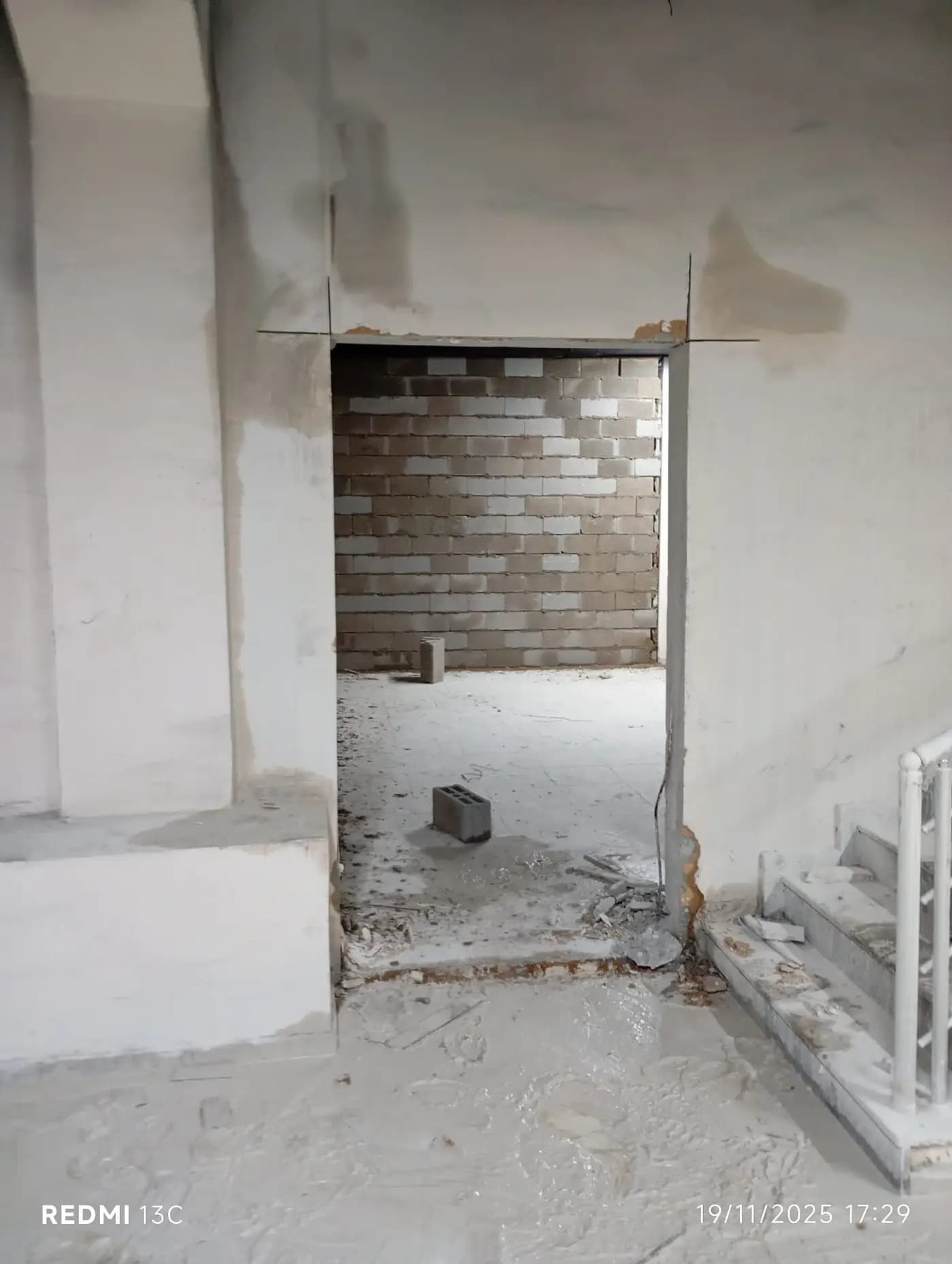 Sıvalı iç duvarda düz kenarlarla açılmış kapı boşluğu ve boşluğun ardındaki bitişik hacim