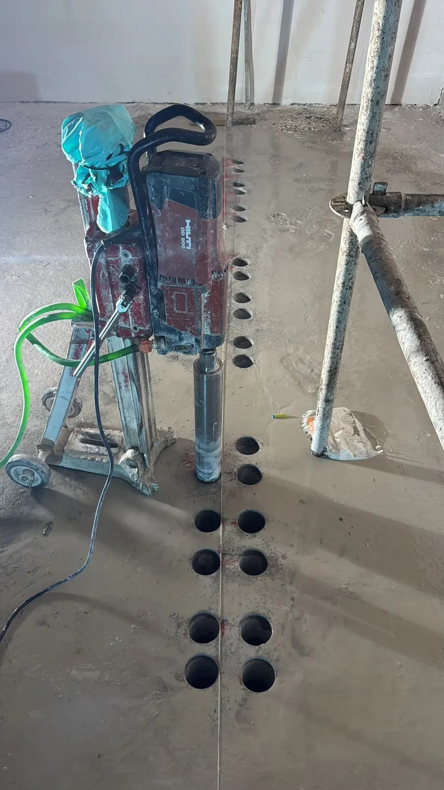 Sehpasına bağlı Hilti DD 200 karot makinesi ve yanında açılmış çift sıra karot deliği