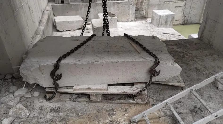Ahşap takozlar üzerine oturtulmuş, sapan geçirmek için altı boşaltılmış kesilmiş beton blok