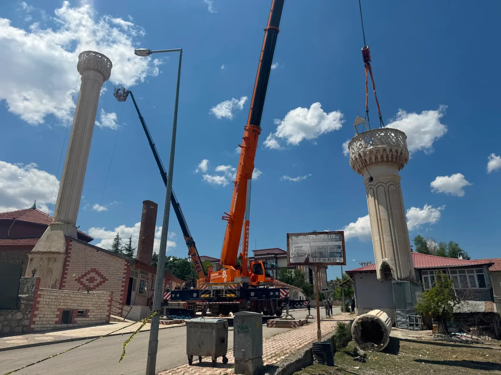 Kesilen şerefe parçasının vinçle havada taşınması, solda kalan minare gövdesi