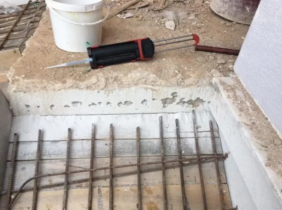 Pürüzlendirilmiş beton ek yüzeyi, üzerinde duran kimyasal ankraj tabancası ve serilmiş hasır donatı