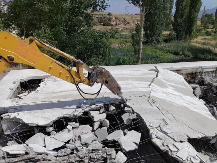 Ekskavatör kırıcısının betonarme çatı döşemesini kırması ve açığa çıkan hasır donatı