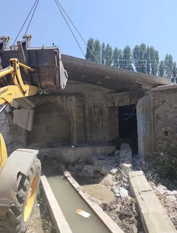Yükleyici kovasıyla kaldırılan tavan döşemesi bölümü ve altında açığa çıkan kemerli taş yapı